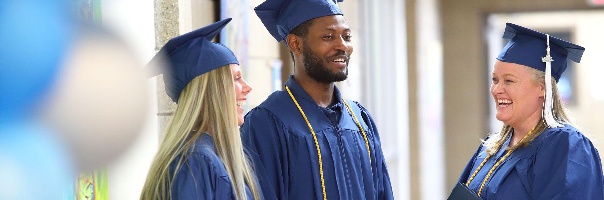 Southeast Tech graduates in cap and gown laughing